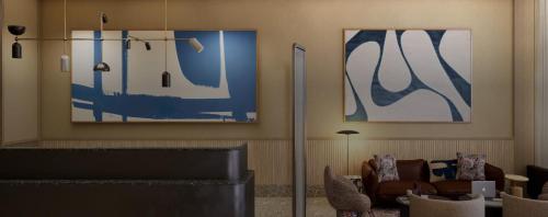 a living room with blue and white paintings on the wall at Kimpton Era Midtown New York by IHG in New York