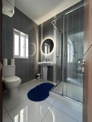 a bathroom with a shower and a toilet and a sink at Park Lane Experience Apartments in Il-Gżira