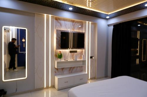 a man standing in a bedroom with a mirror at lucknowi stay in Lucknow