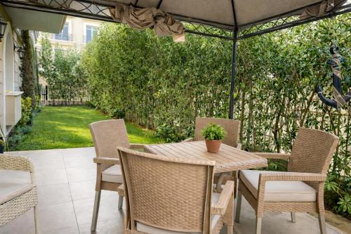 a table and chairs under an umbrella on a patio at Elegant Hydepark Apt With Garden in New cairo
