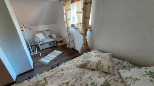 a bedroom with a bed and a window and a chair at Bori Guest House in Miercurea-Ciuc