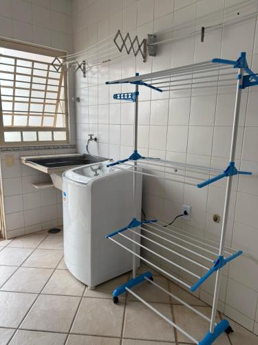 a kitchen with a washing machine in a room at Quarto em ótima localização in Botucatu