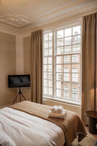 a bedroom with a bed with two towels on it at ADAM & EVE Paleisstraat in The Hague