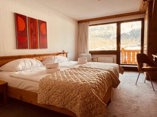 a bedroom with a bed and a large window at Ferienwohnungen Albana in Silvaplana