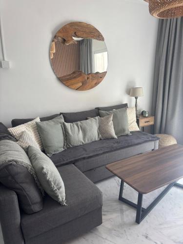 a living room with a couch and a circular mirror at Perfect Location 2 Bed Apart Medina Del Zoco in Sitio de Calahonda