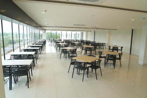 a dining room with tables and chairs and windows at Firefox Hotel and Resort in Moinabad
