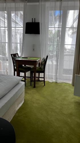 a dining room with a table and chairs with green carpet at Wanderer und Radlerzimmer in Lieser
