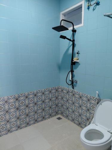 a bathroom with a toilet and a shower at Blue Beach Villa Anyer in Pasauran