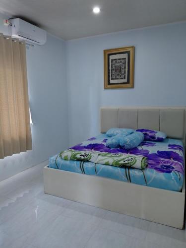 a white bedroom with a bed with blue sheets at Blue Beach Villa Anyer in Pasauran
