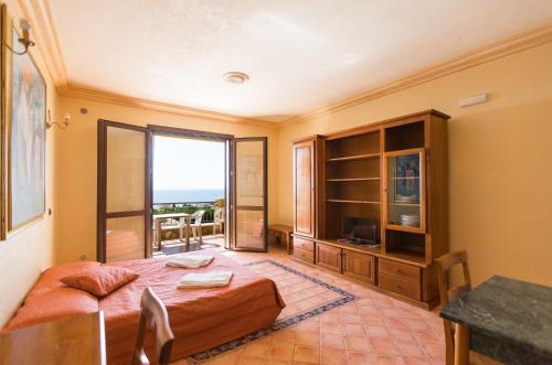 a bedroom with a bed and a sliding glass door at Triscinamare Hotel Residence in Triscina
