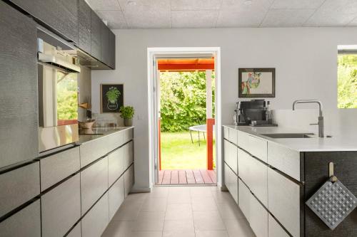 a kitchen with a sink and a door to a yard at Mårslet - close to ocean and city in Mårslet