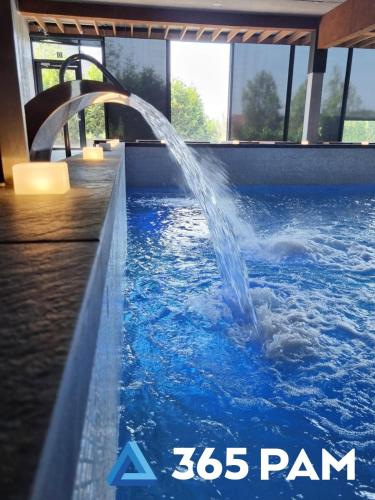 a water fountain in a swimming pool at 365PAM - Apartament nr 32 w Mielenku - BASEN KRYTY, ANIMACJE DLA DZIECI, JACUZZI, SAUNA,PLAC ZABAW W CENIE in Mielenko