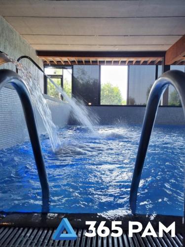 a swimming pool with a water fountain in the middle at 365PAM - Apartament nr 32 w Mielenku - BASEN KRYTY, ANIMACJE DLA DZIECI, JACUZZI, SAUNA,PLAC ZABAW W CENIE in Mielenko