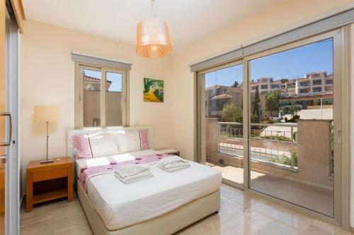 a bedroom with a bed and a large window at Villa Panorama Tria in Drousha