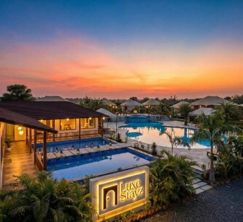 a resort with a large swimming pool at sunset at Luxe Stayz Signature Pushkar in Pushkar