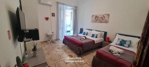 a hotel room with two beds and a television at Casa vacanze Andry in Cinisi
