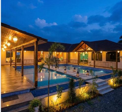 a house with a swimming pool at night at Luxe Stayz Signature Pushkar in Pushkar