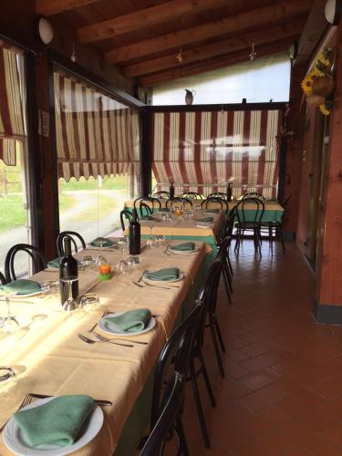 a row of tables in a barn with green napkins at Agriturismo La Selva in Aulla