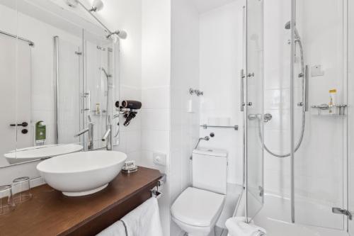 a bathroom with a sink and a toilet and a shower at Cityhotel Amadeus - 3 Sterne Superior in Münster