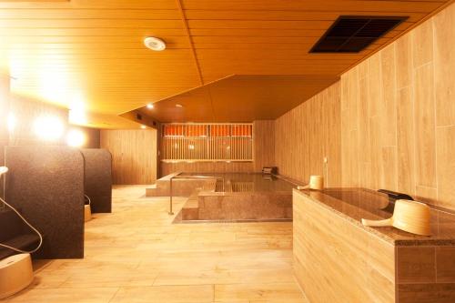a large bathroom with a tub and wooden walls at Kumamoto Washington Hotel Plaza in Kumamoto