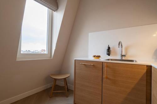 a kitchen with a sink and a window at Hotel Zest Den Haag - Scheveningen in Scheveningen