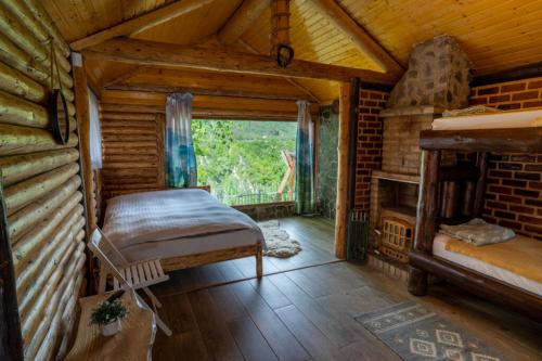 a bedroom in a log cabin with a bed and a fireplace at Bârlogul Vikingilor in Şotrile