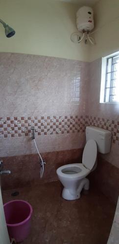 a bathroom with a toilet and a window at 3BHK - Bamboo Private Pool Villa Yercaud in Yercaud