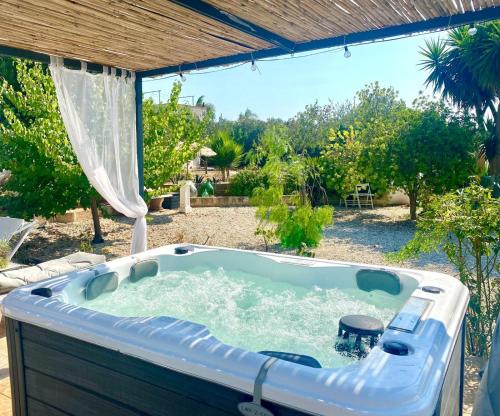 a jacuzzi tub in the backyard of a house at Secret Garden Chalet No. 1 in San Pietro in Bevagna