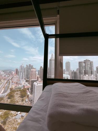 a bed in a room with a view of a city at Poshpack Skyline Hostel in Kuala Lumpur