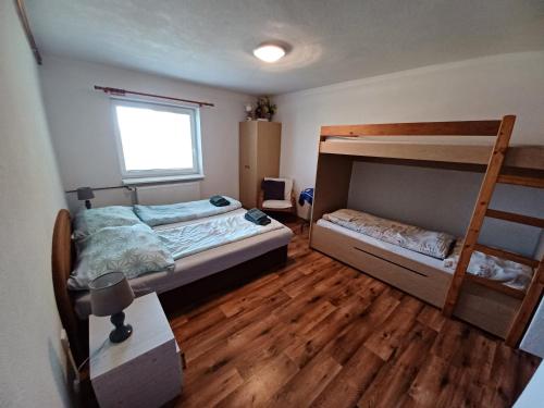 a bedroom with two bunk beds and wooden floors at Chaty Antónia in Hriňová