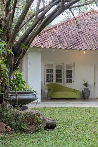 a green couch sitting outside of a house at Heuvel Villa Kandy in Kandy