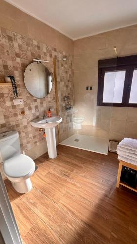 a bathroom with a toilet and a sink and a shower at Apartamento La Hera in Belvis de Monroy