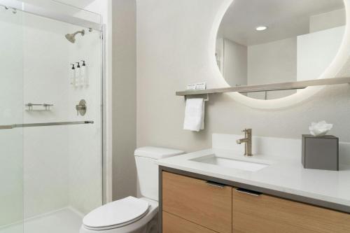 a bathroom with a toilet and a sink and a mirror at TownePlace Suites by Marriott Lafayette in Lafayette
