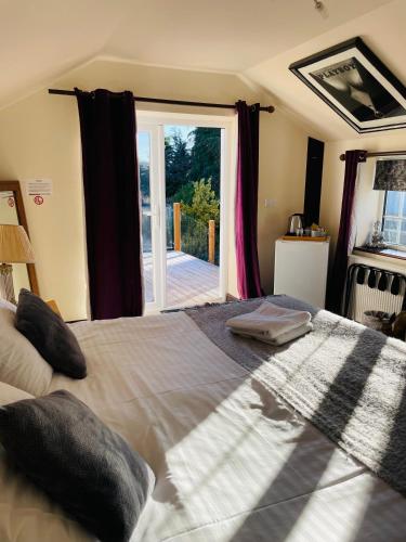 a bedroom with a large bed and a large window at Jasmine House in Lutterworth