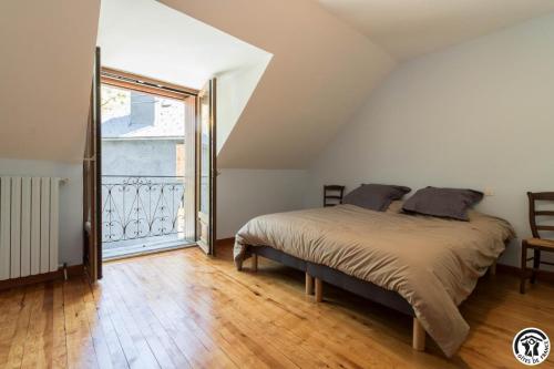 a bedroom with a bed and a large window at Calme et montagne in Cazaux-Layrisse