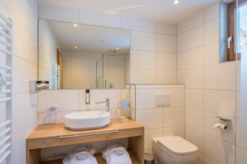 a bathroom with a sink and a toilet at Hotel Alpenkönigin - ALPINE LUXURY in See