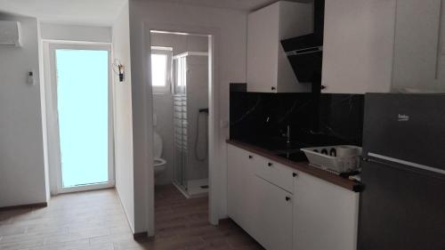 a white kitchen with a sink and a toilet at Vila Azzuro in Žusterna