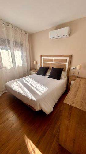 a bedroom with a large white bed with two pillows at Apartamento La Hera in Belvis de Monroy