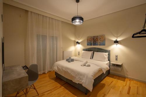 a bedroom with a large white bed and a chair at Meteora Rockside Lodge in Kalabaka