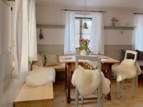 a dining room with a table with white chairs and a couch at Altes Zollhaus in Neukirchen