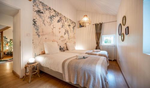 a bedroom with two beds in a room at L'Orée du Bois in La Charmée