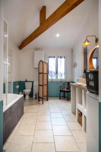 a bathroom with a tub and a toilet and a sink at L'Orée du Bois in La Charmée