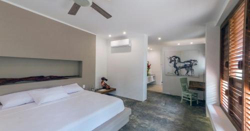 a bedroom with a large white bed in a room at Villa Playa Tayrona, Los Naranjos in Los Naranjos