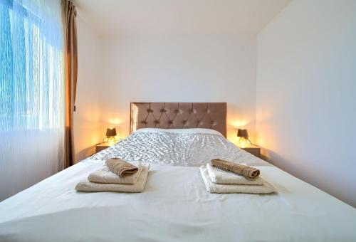 a bedroom with a white bed with towels on it at Luxury-relax residence Muraj in Kornić
