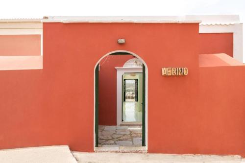 a red building with a sign that says mexico at Aerino in Symi