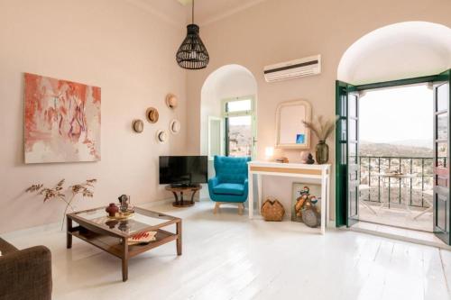 a living room with a couch and a table and a tv at Aerino in Symi