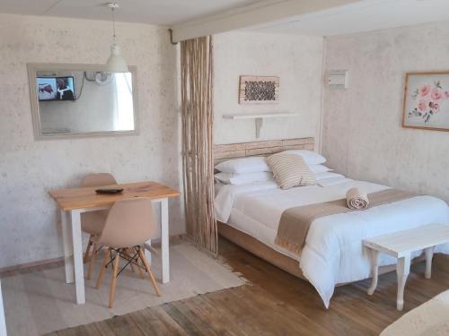 a bedroom with a bed and a table and a desk at Brakvlei in Albertinia