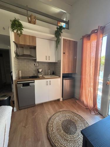 a kitchen with white cabinets and a rug on the floor at Caseta Cosi in Vic-la-Gardiole