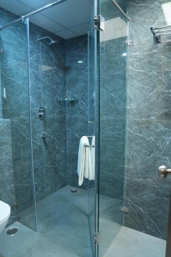 a bathroom with a shower with a glass door at Firefox Hotel and Resort in Moinabad