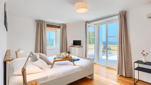 a bedroom with a bed with a view of the ocean at Villa Pigini by Villas Guide in Livade